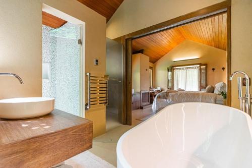 a bathroom with a large tub and a bedroom at Villa Tanah in São Roque