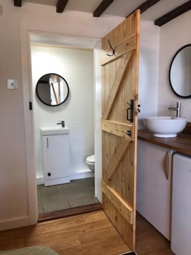 a bathroom with a wooden door and a sink at Sunrise Studio in Colchester