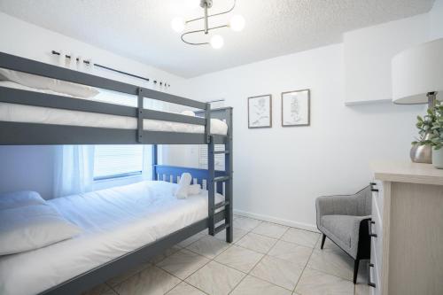 - une chambre avec 2 lits superposés et une chaise dans l'établissement Modern 3-Bedroom in the Heart of Wynwood Art District, à Miami