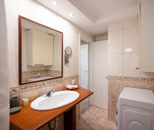 y baño con lavabo, espejo y aseo. en ioli Corfu maisonette, en Kastanéa