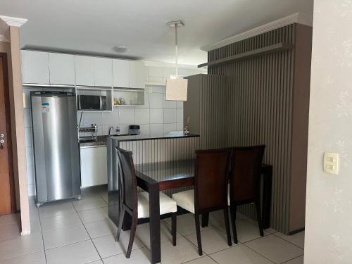 a kitchen with a table and chairs and a refrigerator at APARTAMENT BEACH FORTALEZA in Fortaleza