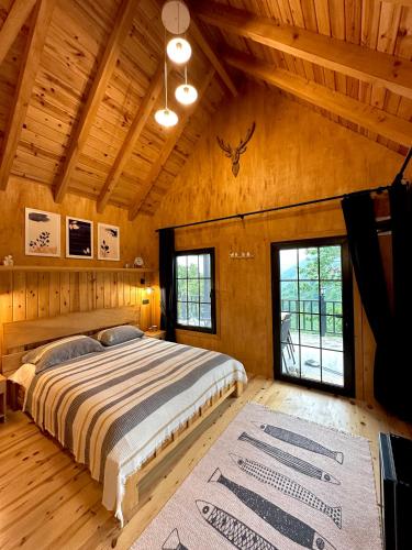 a bedroom with a large bed in a wooden cabin at Varya Tatil Köyü in Çamlıhemşin