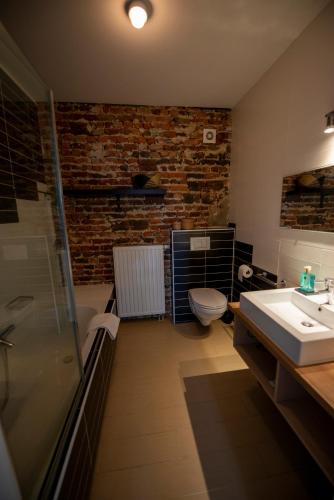 a bathroom with a shower and a sink and a toilet at Boutique Hotel Het Zoete Zijn in Borgloon
