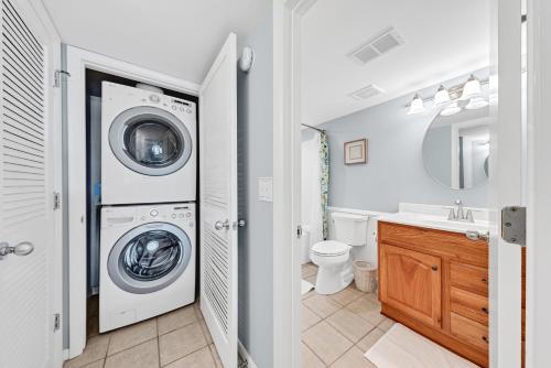 ein Badezimmer mit einer Waschmaschine und einem Waschbecken in der Unterkunft 2935 Atrium Villa in Seabrook Island