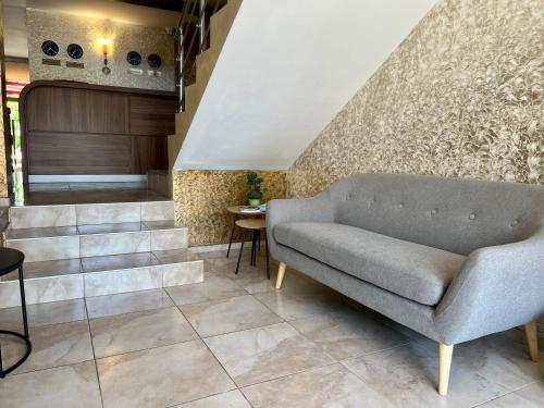 a living room with a couch and stairs at Family Hotel Kontesa in Lozenets