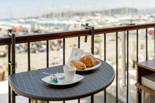 a table with a cup of coffee and pastries on a balcony at Kisses House - MARINA GRANDE PORT in Procida