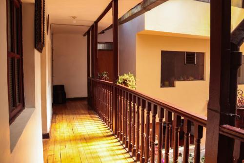 um corredor de uma casa com um corrimão de madeira em HOSTAL QORI KANCHA'S INN em Cusco