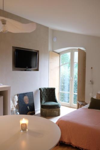 une chambre avec un lit, une table et une télévision dans l'établissement Studio Confort +, à Saint-Étienne