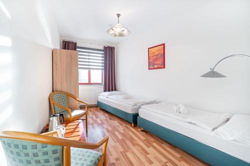 a room with two beds and a chair at Penzion LAGUNA in Přimda