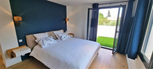 une chambre avec un lit blanc et une grande fenêtre dans l'établissement Magnifique villa 3 chambres Saint Paul de Vence, à Saint-Paul-de-Vence