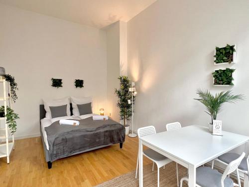 1 dormitorio con 1 cama, mesa y sillas en Jungle Retreat Apartments im Zentrum, en Bremen