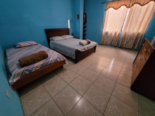 1 dormitorio con 2 camas y suelo de baldosa en Departamento Familiar en Santa Cruz, en Puerto Ayora