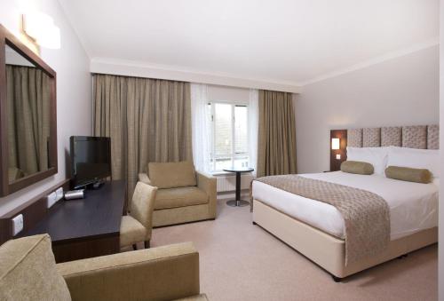 a hotel room with two beds and a television at Sudbury House in Faringdon