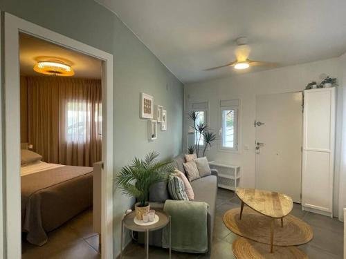 ein Wohnzimmer mit einem Bett, einem Sofa und einem Tisch in der Unterkunft La casita blanca - Bungalow 20m from the sea! in Miami Platja