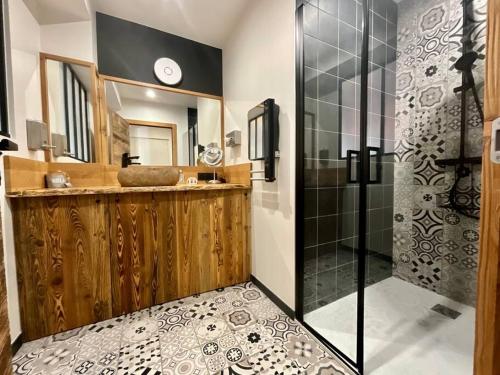 une salle de bain avec une douche, un lavabo et un miroir dans l'établissement L’Appart Gabriela, gîte de standing hypercentre, à Gérardmer