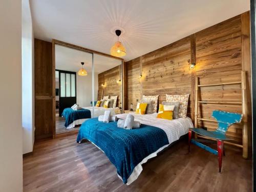 une chambre avec deux lits et un miroir dans l'établissement L’Appart Gabriela, gîte de standing hypercentre, à Gérardmer