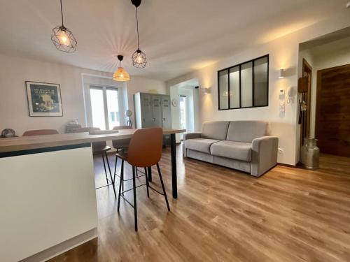 un salon avec un canapé, une table et des chaises dans l'établissement L’Appart Gabriela, gîte de standing hypercentre, à Gérardmer