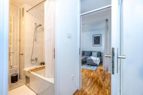 a bathroom with a shower and a bath tub next to a bedroom at Mountain View Apartment Lika**** in Gospić