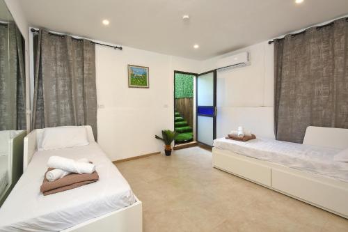 2 Betten in einem Zimmer mit Fenster in der Unterkunft Levication 2 bedrooms Pool&jacuzzi in Tiberias
