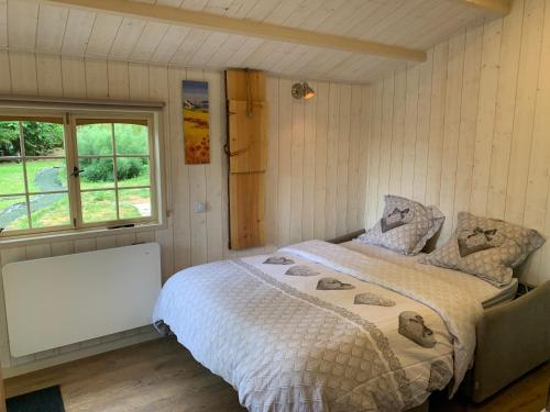 um quarto com uma cama e uma janela em Chalet cosy bord de Seine 30min paris em Carrières-sous-Poissy