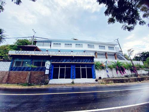 a blue and white building on the side of a street at Anugrah Hotel in Teluk Nara