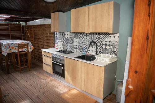 a kitchen with a stove and a sink and a table at Chambres d'hôtes du domaine des doudous in Saint-Pierre