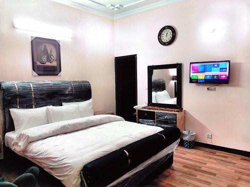 um quarto com uma cama, um espelho e uma televisão em Frank in guest house em Islamabad