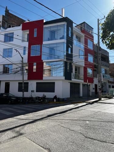 a red and white building on the side of a street at Hotel SOGU TOWER in Ayacucho