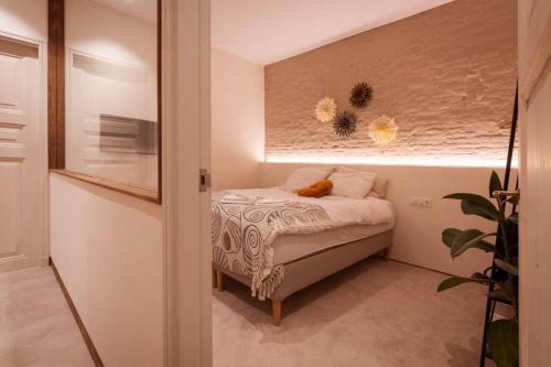 Appartement met tuin in Haarlem centrum(Vijfhoek) في هارلم: غرفة نوم صغيرة مع سرير في غرفة