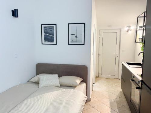 a white room with a bed and a kitchen at Black n’ White in Dubrovnik