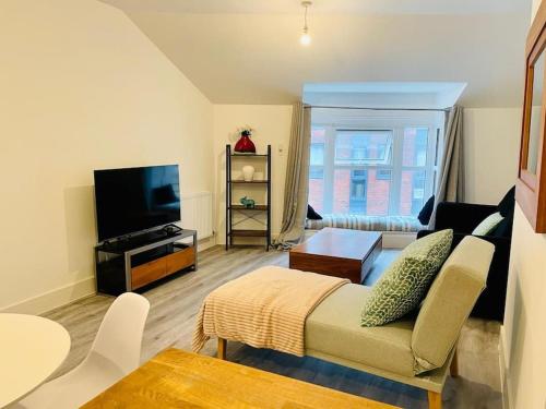 a living room with a couch and a tv at Central modern 1 Bed 1 Bath flat in Woking