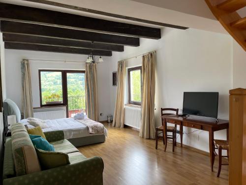 a living room with a bed and a desk with a computer at Pensiunea La Maison in Bran