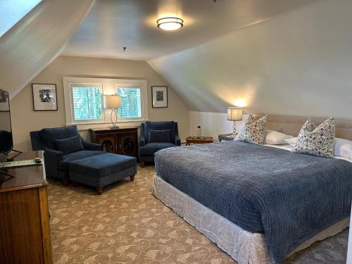 a bedroom with a bed and a couch and chairs at West End Guest House in Vancouver