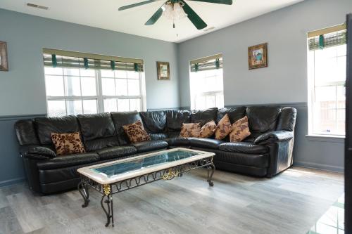 a black leather couch in a living room with a coffee table at AMAZING!!!! Luxury 5BR, Steps to beach and Fun! Fully Renovated Beach house! in Atlantic City