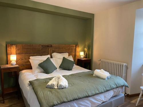 ein Schlafzimmer mit einem großen Bett mit grünen Wänden in der Unterkunft Le Val Éveillé - maison de maître de 1773 - 4* in Arudy