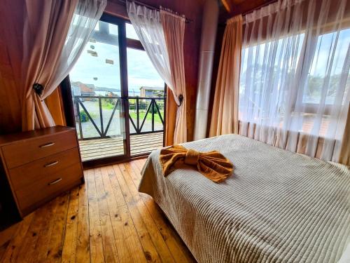 a bedroom with a bed and a large window at Cabañas Kompatzki in Ancud