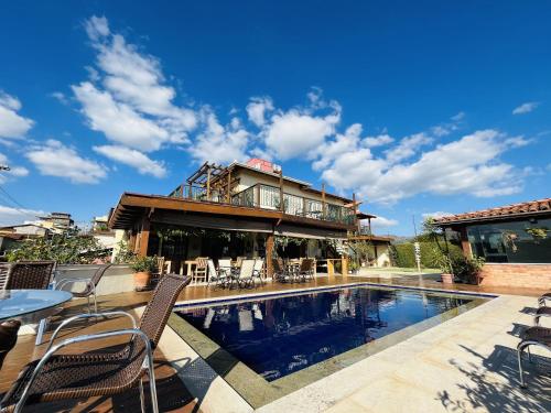 a house with a swimming pool in front of a house at Pousada Quintal da Lua in Capitólio
