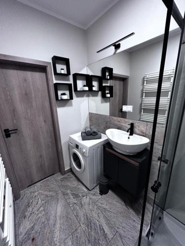 ein Badezimmer mit Waschmaschine und Waschbecken in der Unterkunft Apartament Walczaka 47 MIEJSCE PARKINGOWE in Gorzów Wielkopolski