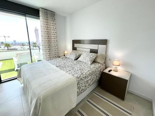 - une chambre avec un grand lit et une grande fenêtre dans l'établissement SEASCAPE LUXURY APARTMENT, à Finestrat