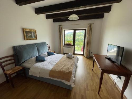 a bedroom with a bed and a desk and a television at Pensiunea La Maison in Bran