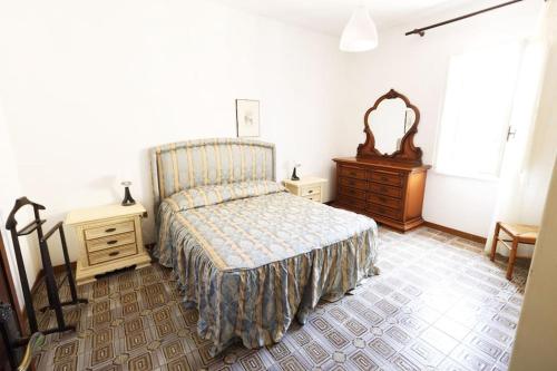 een slaapkamer met een bed, een dressoir en een spiegel bij [cav Maura] relax toscana in Crocina