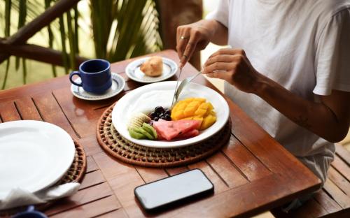 a person eating a plate of food on a table at Chalé Sienna Ar condicionado Pousada 35knots Brasil in Luis Correia