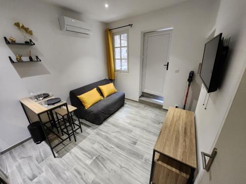 un petit salon avec un canapé et une table dans l'établissement Studio climatisé avec cour privé en Rez-de-chaussée centre historique, à Avignon