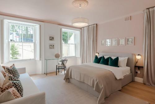a white bedroom with a large bed with green pillows at Lux and Spacious 4 bedroom apt Camden in London