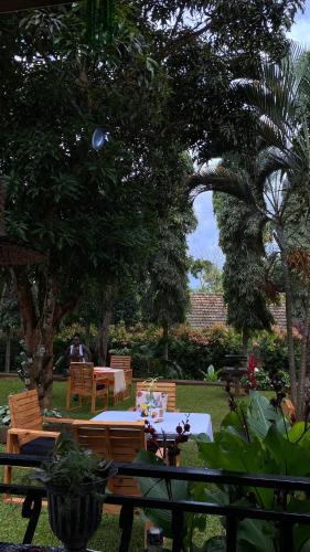 a table and chairs in a garden with a person sitting at a table at Aivilo Home in Kampala