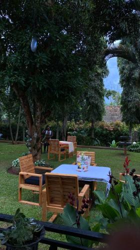a table and chairs in a yard with a tree at Aivilo Home in Kampala