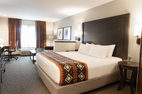 a hotel room with a large bed and a desk at Oxford Suites Pendleton in Pendleton