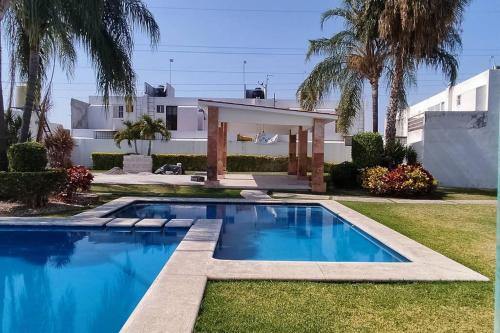 a swimming pool in front of a house at Casa cerca de ex hacienda temixco in Morelos
