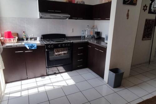 a kitchen with brown cabinets and a stove top oven at Casa cerca de ex hacienda temixco in Morelos