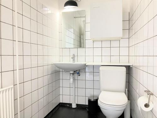 a white bathroom with a toilet and a sink at 1 Bedroom Apartment In Kolding City Center in Kolding